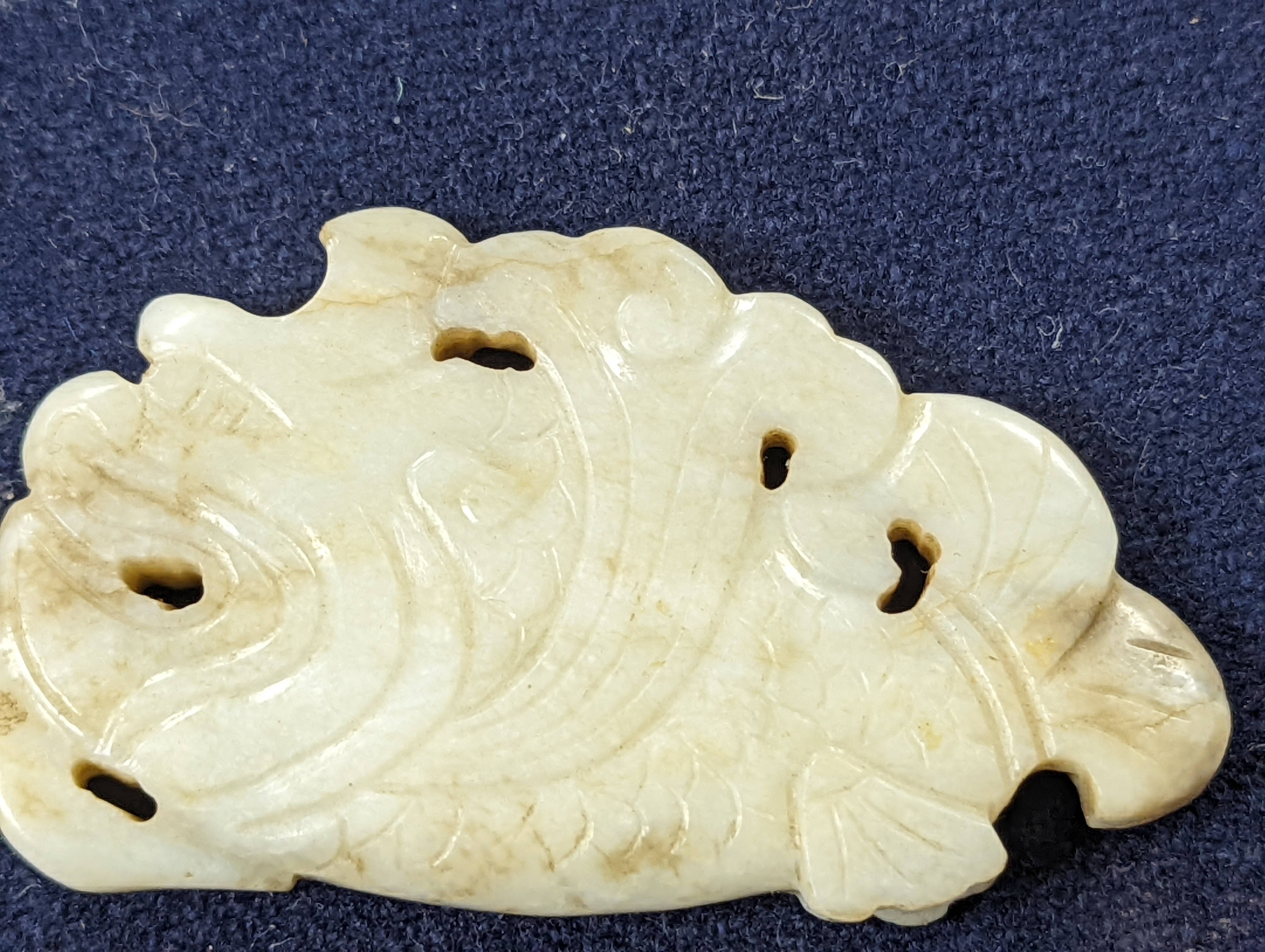 A Chinese white and black jade ‘dragon-fish’ plaque, 19th/20th century, 6cm